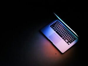 silver macbook air on black table